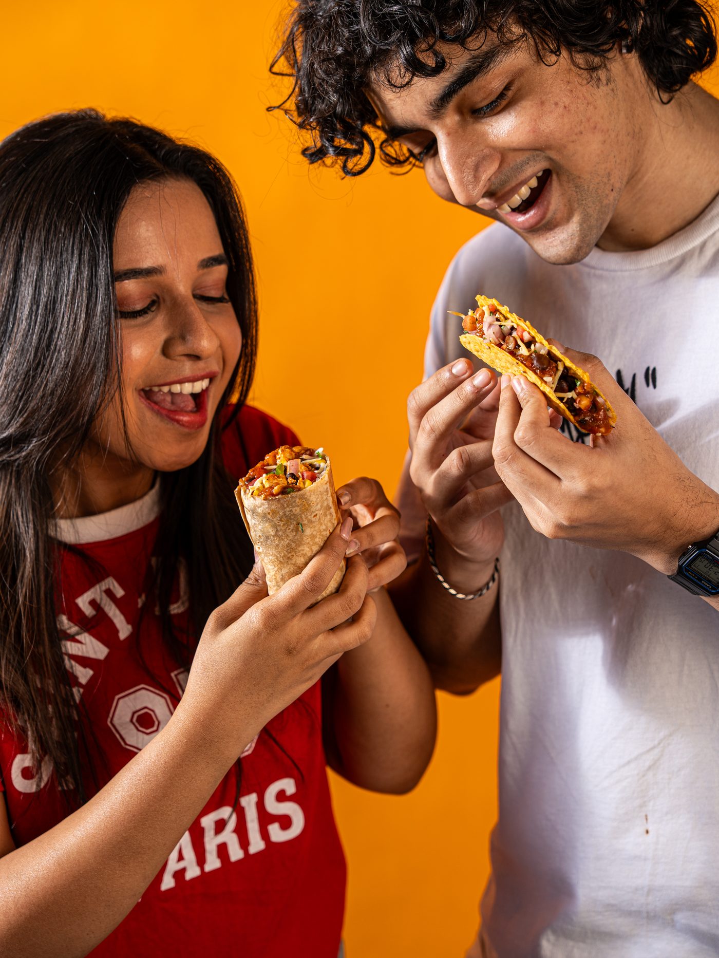 Friends sharing a burrito and taco at Maiz